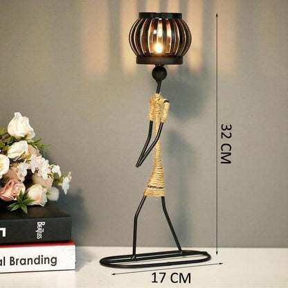 Two metal figurines with candles and books on a table, creating a serene and cozy atmosphere.