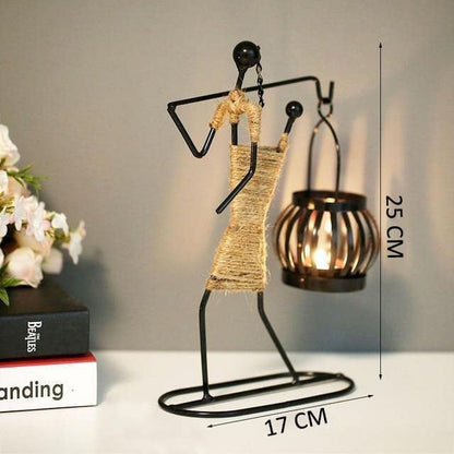Two metal figurines with candles and books on a table, creating a serene and cozy atmosphere.