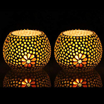 Pair of glowing yellow and black candles on black backdrop