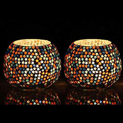 Colorful glass tealights contrast with black background