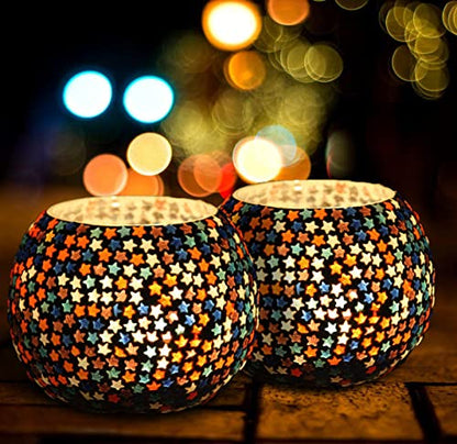 Glass tealights in bright colors on a table.