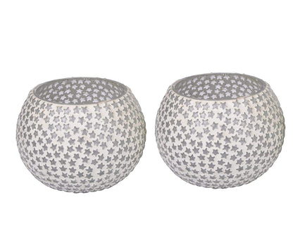 Two tealights, one white and one black, placed on a table.