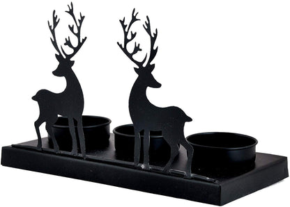 Candlelight casting shadows of two deer in silhouette.