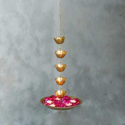 A decorative flower pot suspended in the air, adorned with vibrant flowers and accompanied by flickering candles.