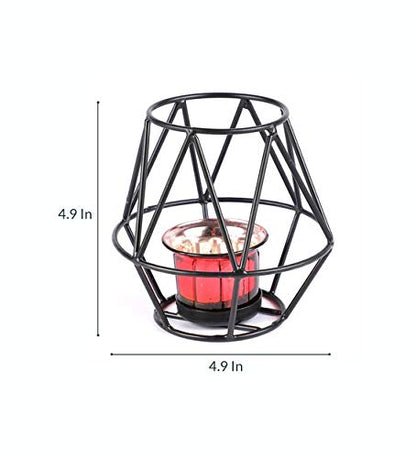 A black candle holder with a red candle burning brightly, casting a warm glow in the room.