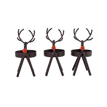 Black reindeer candles on table with red pillow.