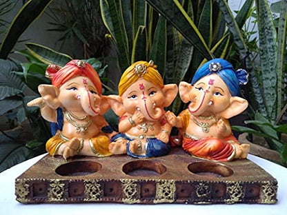 Wooden tray holding three Ganesha figurines.