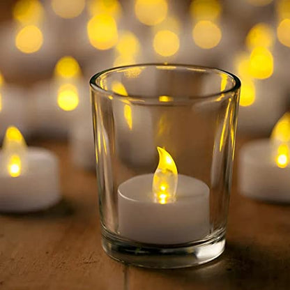  Wooden stand holding four glass votive candles, glowing softly.