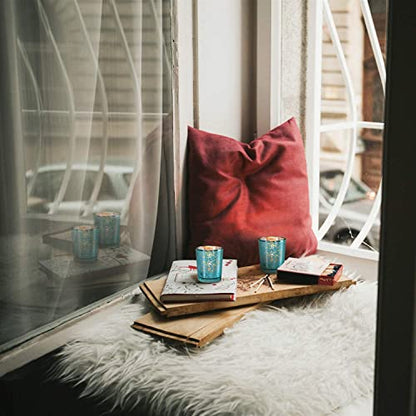 Beautiful teal glass candle holder with lit candles and plate