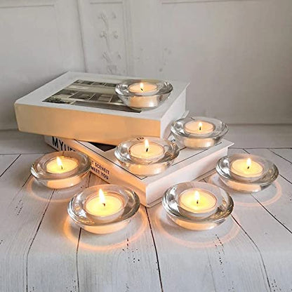 A table with six clear glass tealights arranged neatly in a group.