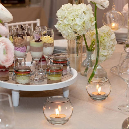 A glowing candle in a clear glass bowl, radiating warmth.