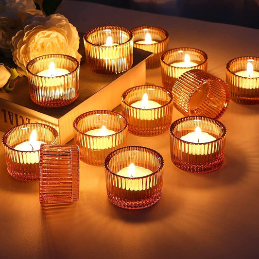 Six lit candles in glass cups on a table