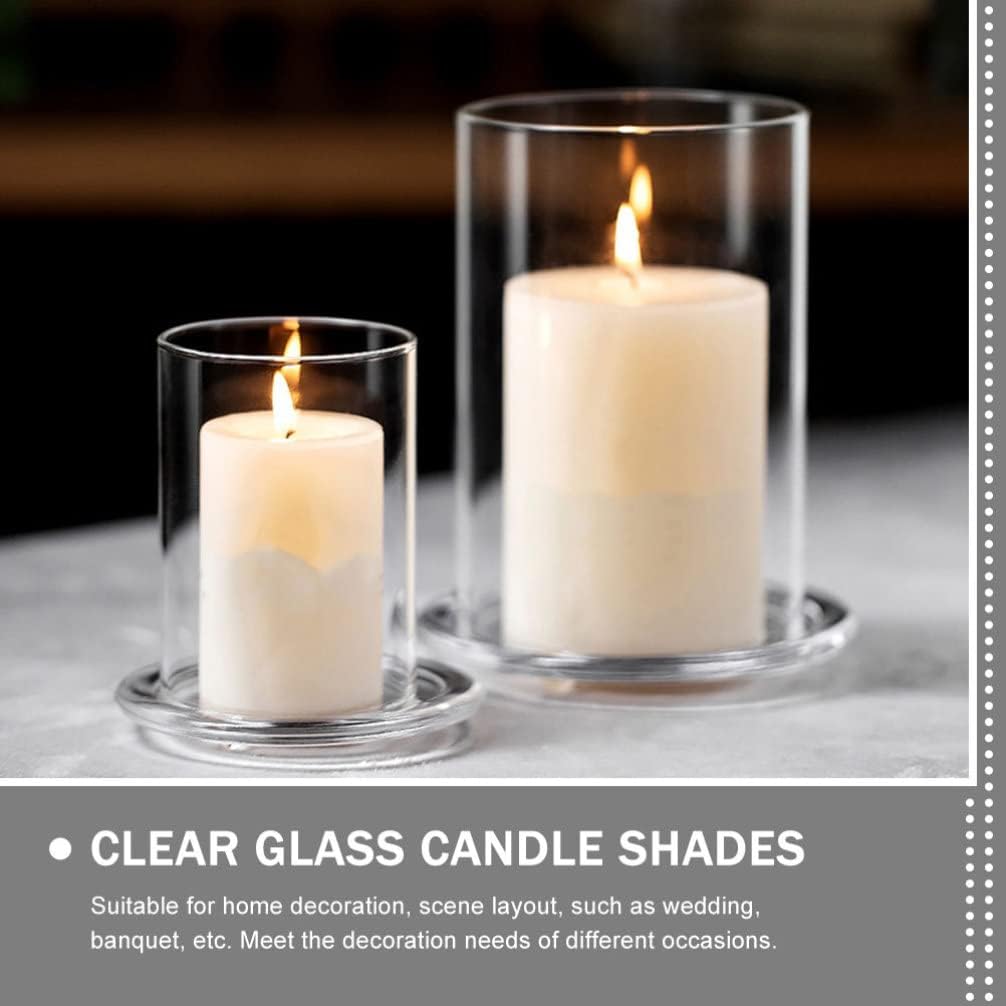 Three glass candles set against white flowers.