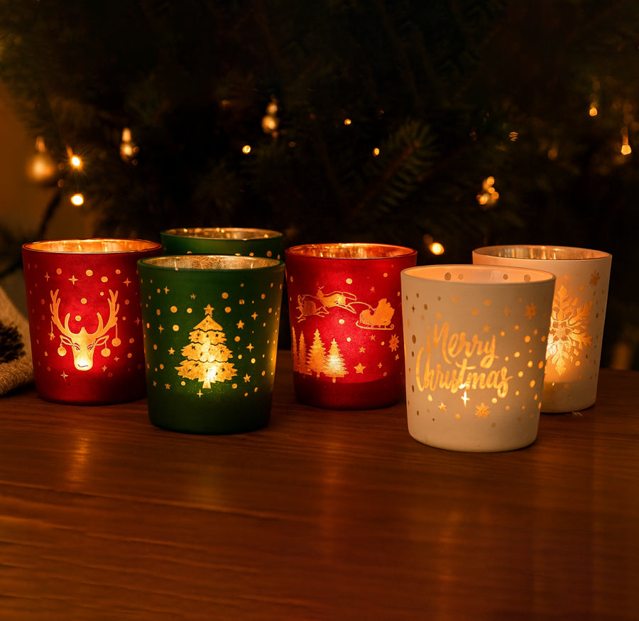 Set of 6 Christmas-themed candle holders on a wooden surface with a blurred festive background.