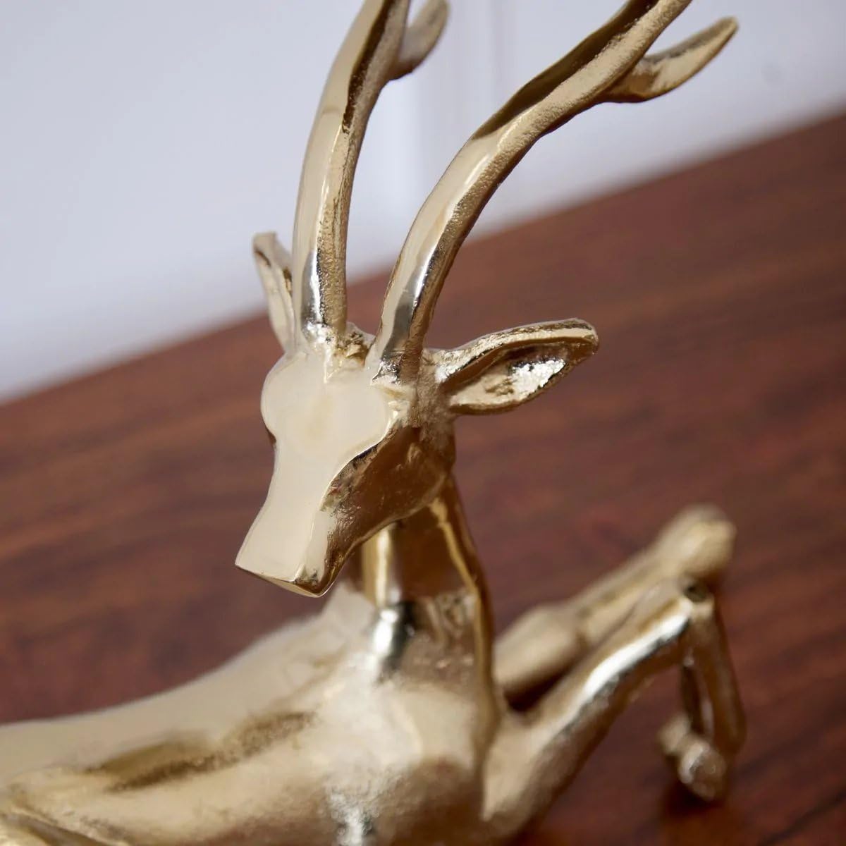 Gold deer figurine on a wooden surface