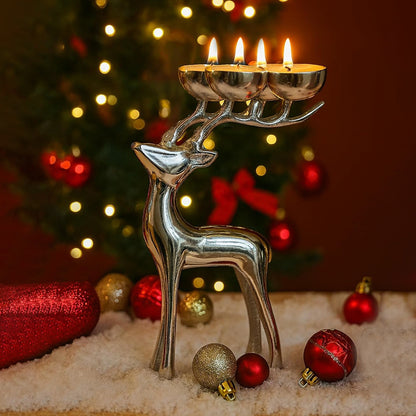 Silver reindeer candle holder with lit candles in front of a Christmas tree.