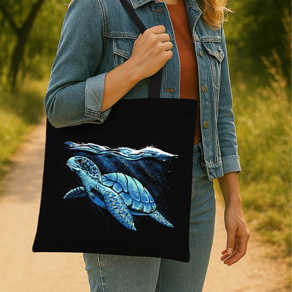 A black tote bag adorned with an image of a sea turtle gliding through ocean waters