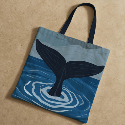 Stylish whale tail tote bag adorned with a blue whale graphic, ideal for carrying essentials while promoting ocean conservation.