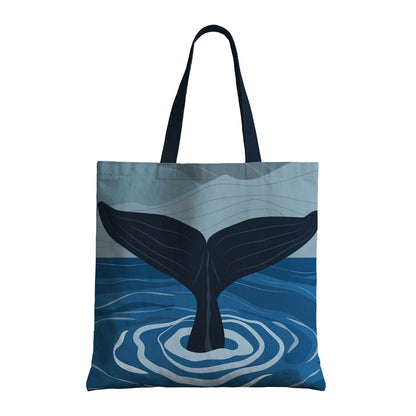 A blue whale illustrated on a whale tail tote bag, merging practicality with a passion for oceanic themes and sustainability.