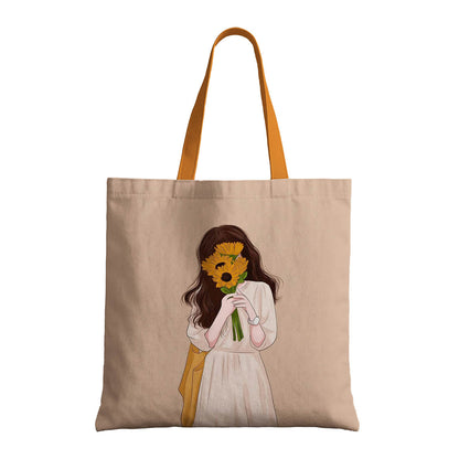 A tote bag showcasing a drawing of a girl with a sunflower in her hands