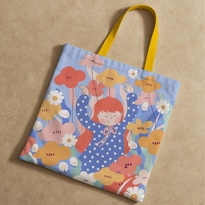 A tote bag illustrated with a girl and an array of flowers, reflecting a playful and artistic theme.