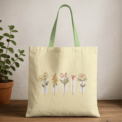 A tote bag featuring a colorful floral design, showcasing various flowers against a neutral background.