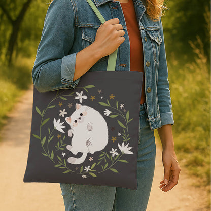 A stylish tote bag adorned with a white cat and vibrant floral designs.