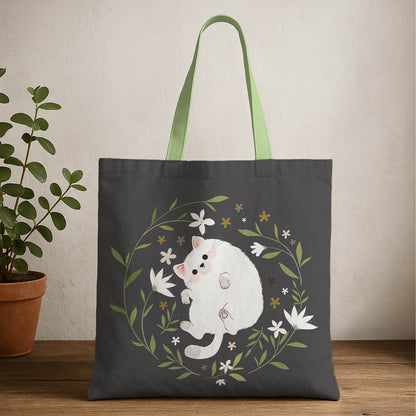 A tote bag featuring a white cat surrounded by colorful flowers on a light background.
