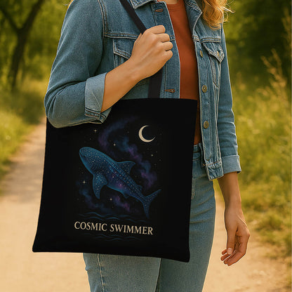 A tote bag adorned with a cosmic swimmer and whale shark graphic, blending celestial elements with aquatic themes in bright colors.
