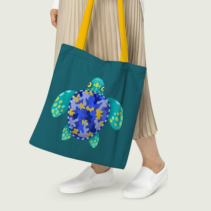 A blue and yellow tote bag with a whimsical turtle design, perfect for casual outings or beach trips.
