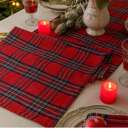 A beautifully arranged table setting featuring red and blue plaid placemats, creating a cozy and inviting atmosphere.