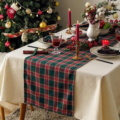 A charming table decorated with a Christmas tree and a red and green plaid tablecloth, ideal for celebrating the season.