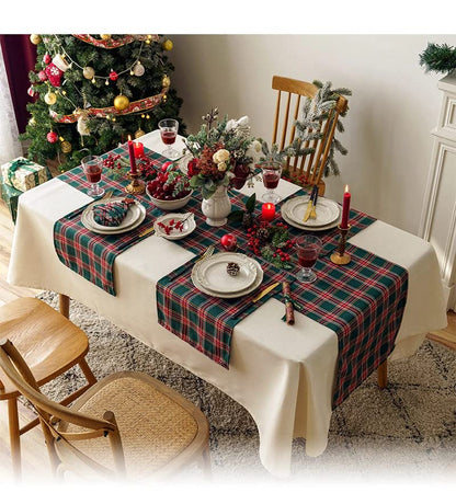 A festive table adorned with a Christmas tree and a red and green plaid tablecloth, creating a cheerful holiday atmosphere.