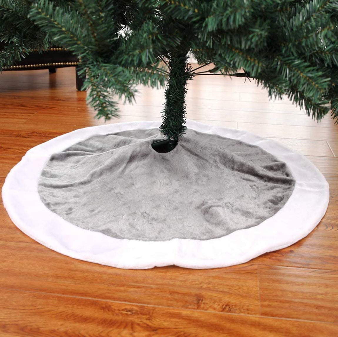 Gray tree skirt with white trim on a Christmas tree