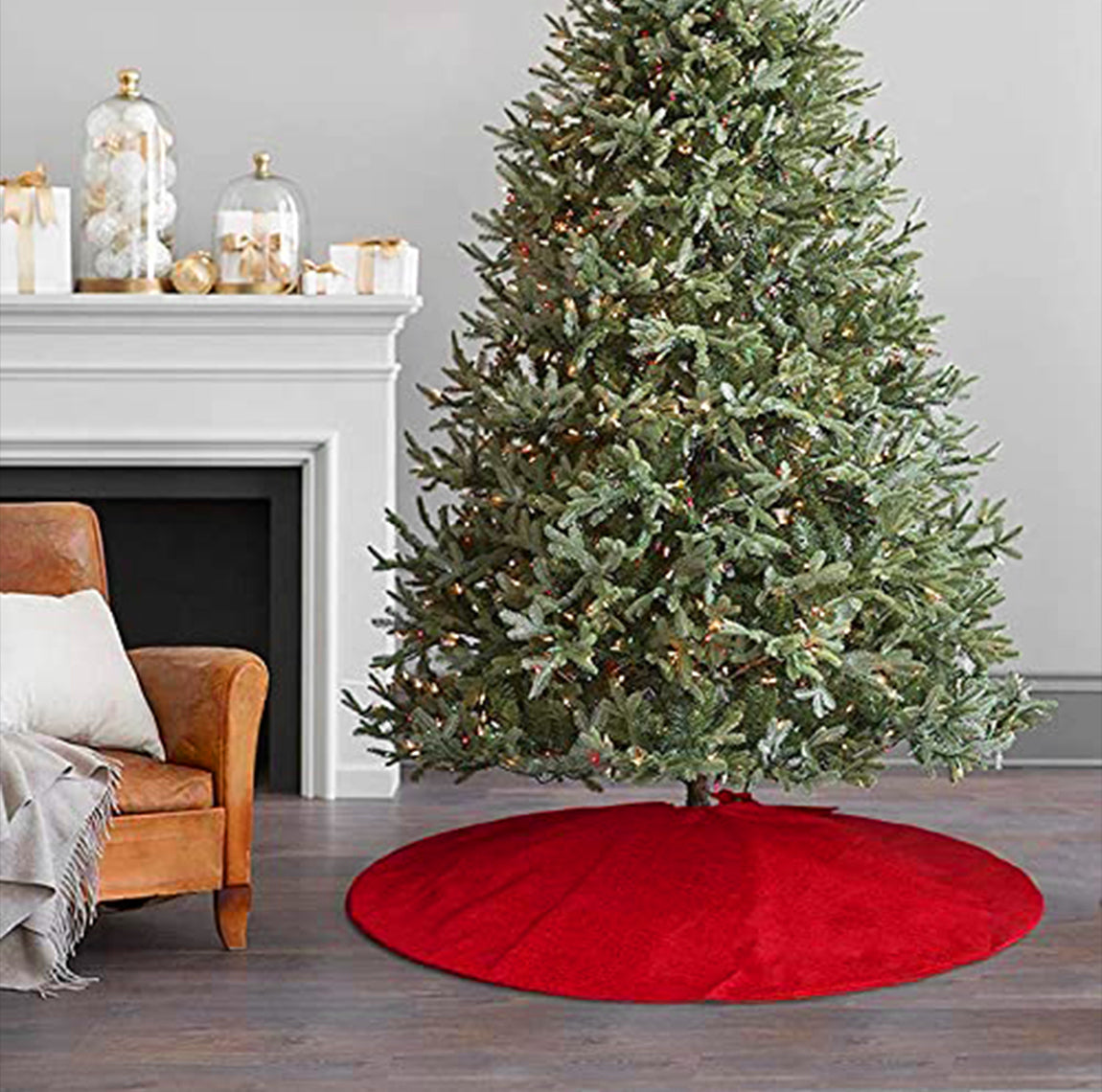 Decorated Christmas tree with a red tree skirt in a living room setting.