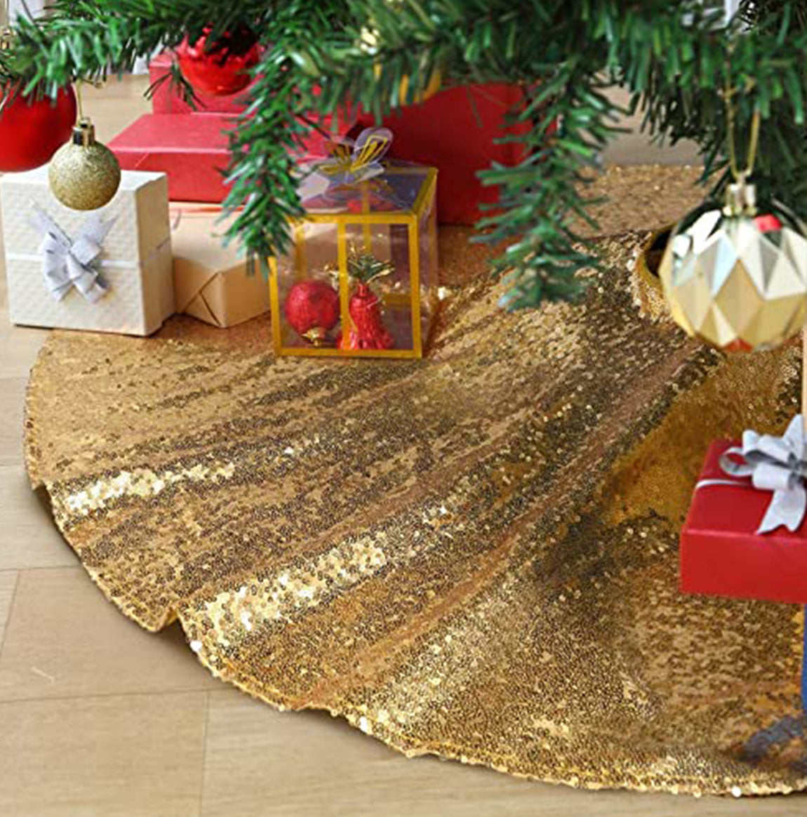 Gold sequin tree skirt under a Christmas tree with presents and decorations.