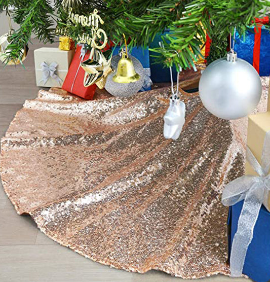 Rose gold sequin tree skirt under a Christmas tree with presents and ornaments.