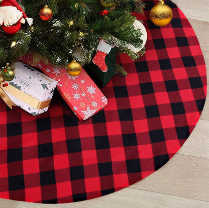 Red and black checkered Christmas tree skirt with a tree, presents, and stockings underneath.