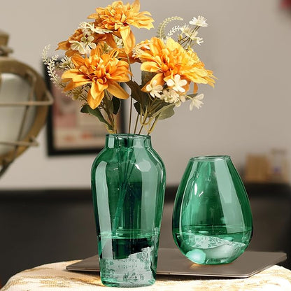 A green vase filled with colorful flowers placed on a desk, adding a touch of nature to the workspace.