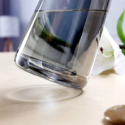 Transparent vase with water on a table.