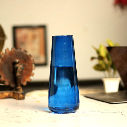 A blue vase with flowers on a table.