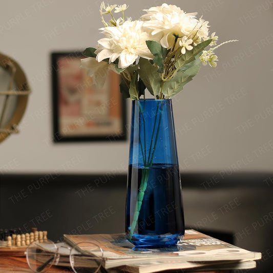 Colorful flowers arranged in a blue vase on a table.