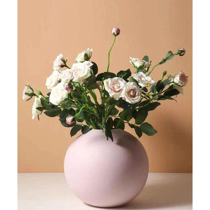 Decorative pink vase holding white flowers, lovely and charming.