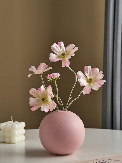  Pink vase with white flowers on table.