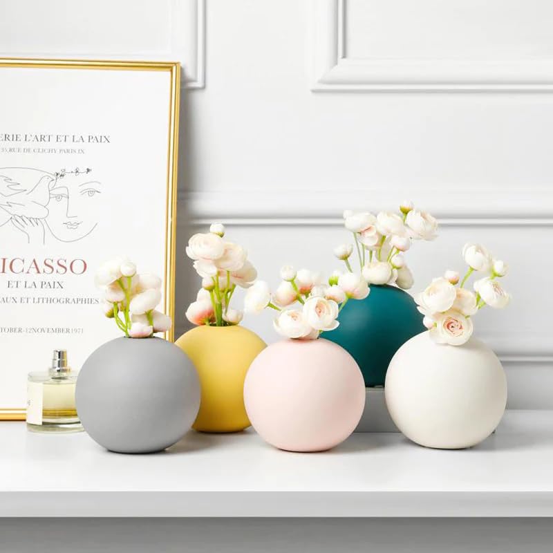 Five  colorful vases filled with fresh flowers on a table.