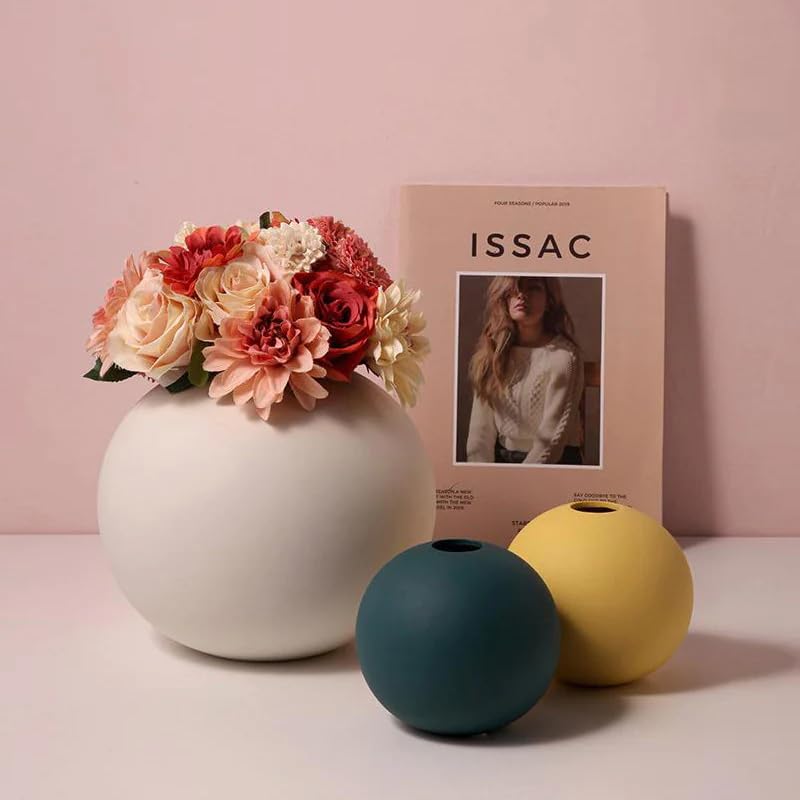 A still life arrangement with a magazine, vase, and flower vase.
