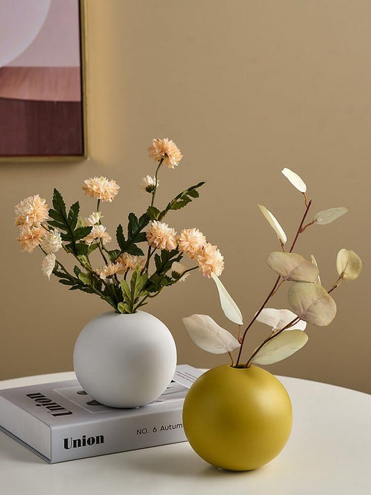 A book and a vase of flowers displayed on a table.