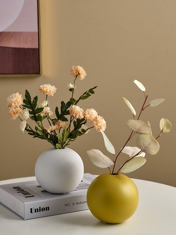 A book and a vase of flowers displayed on a table.