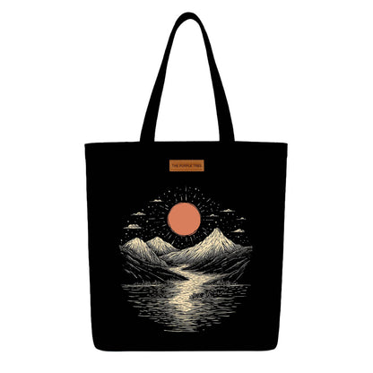 A black tote bag featuring a mountain landscape with a sun, showcasing a serene outdoor scene.