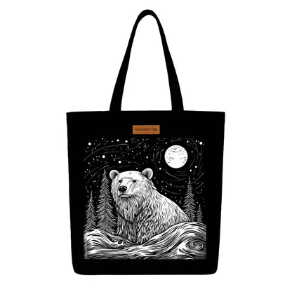 A black tote bag featuring a bear surrounded by trees, showcasing a nature-inspired design.